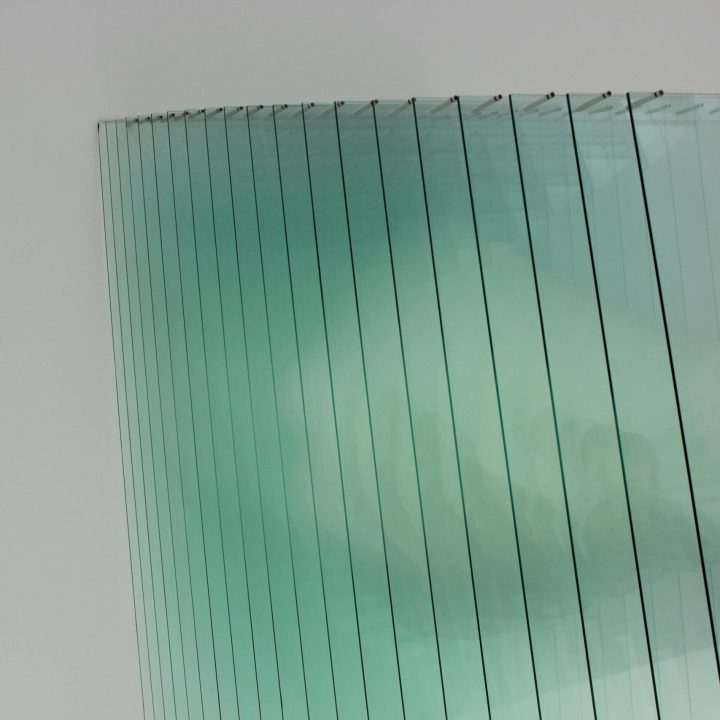 Abstract image showcasing a modern glass panel installation with reflections and a minimalistic design.